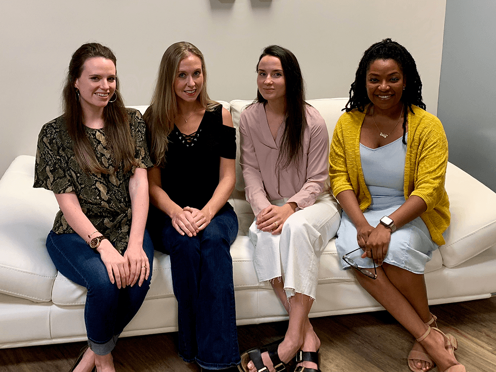 four women sitting on couch choosing employee benefits packages