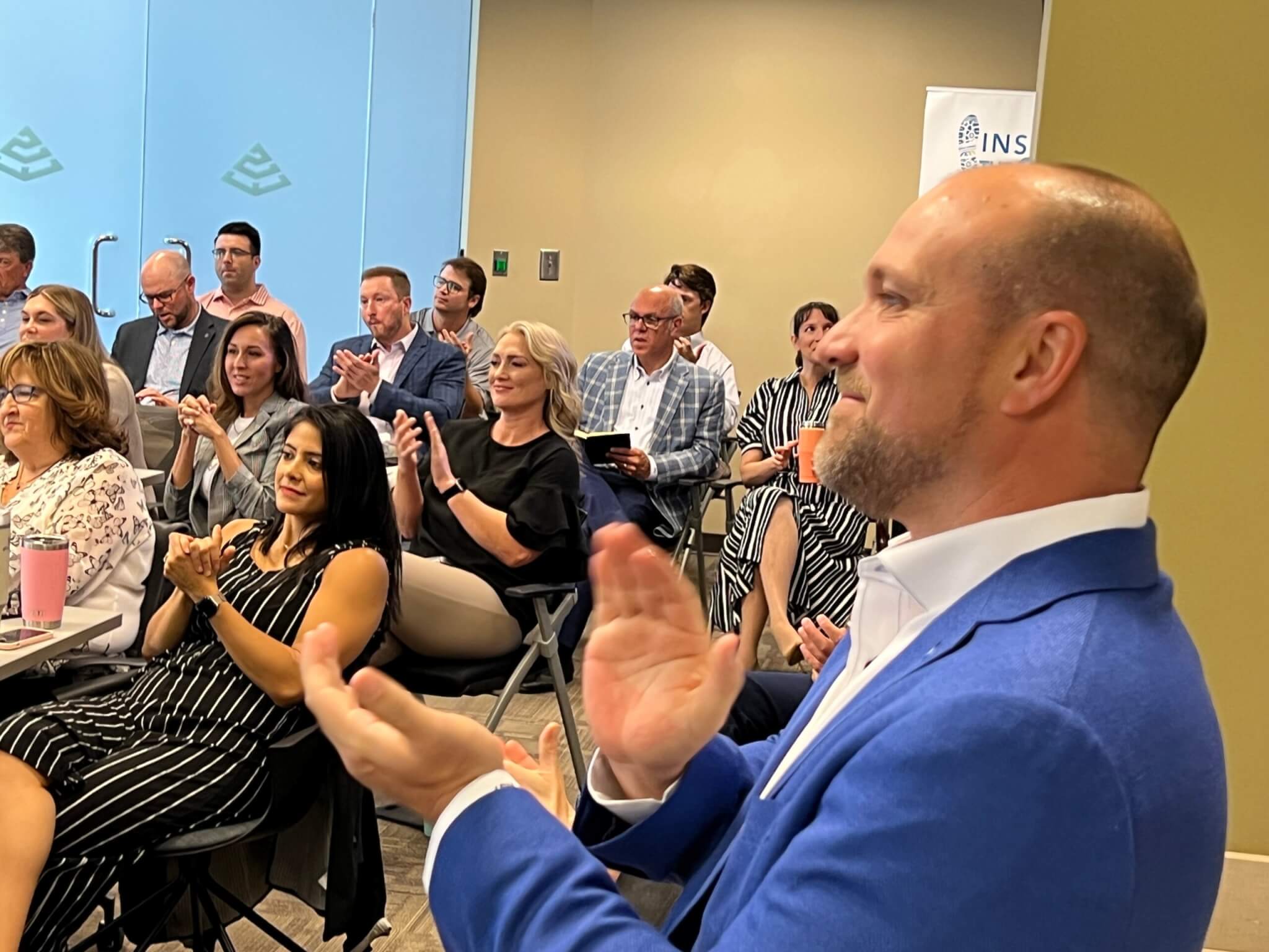 Billy Potter clapping in front of a group of people as partners are awarded our Partner Bravo Awards